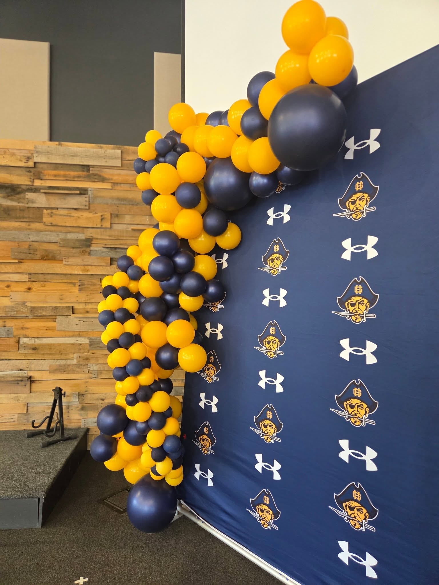 Navy and gold balloon garland against Under Armour Pirates backdrop