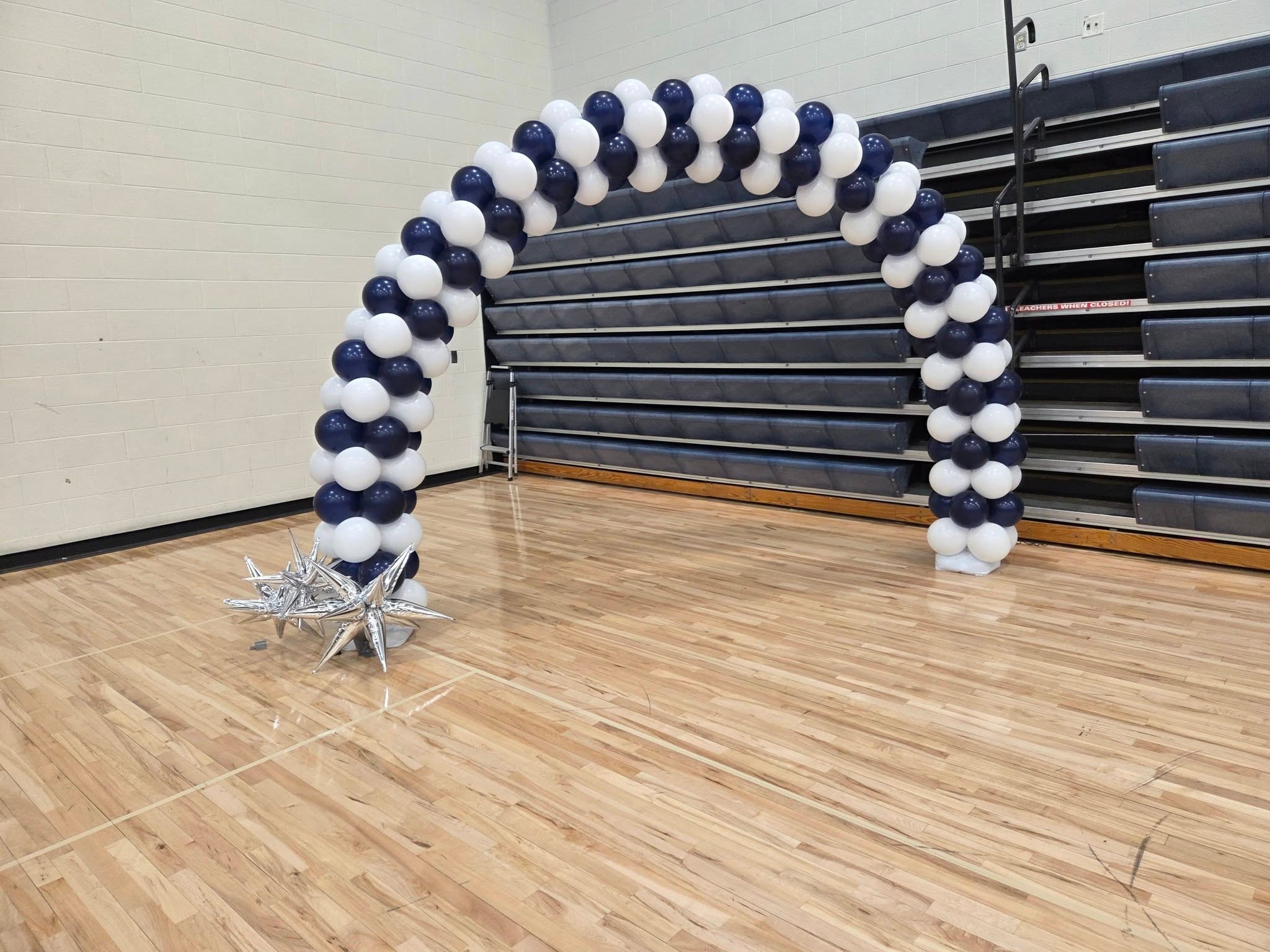 Navy and white classic balloon arch in gymnasium