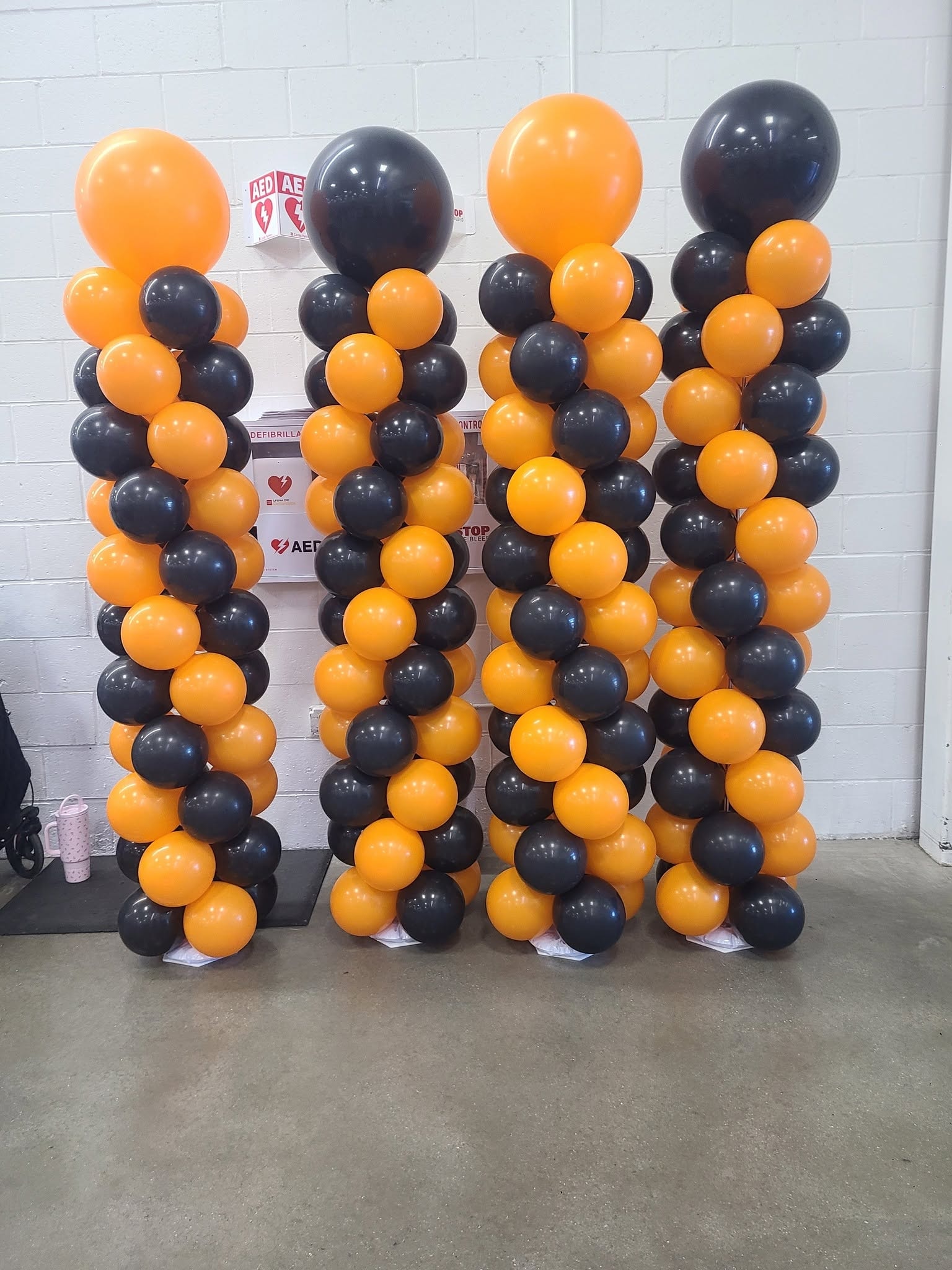 Four orange and black balloon columns