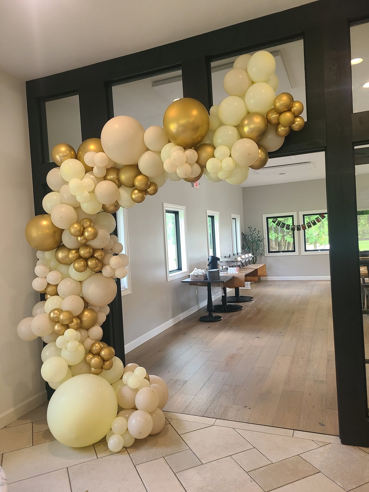 Cream and gold balloon arch framing venue doorway