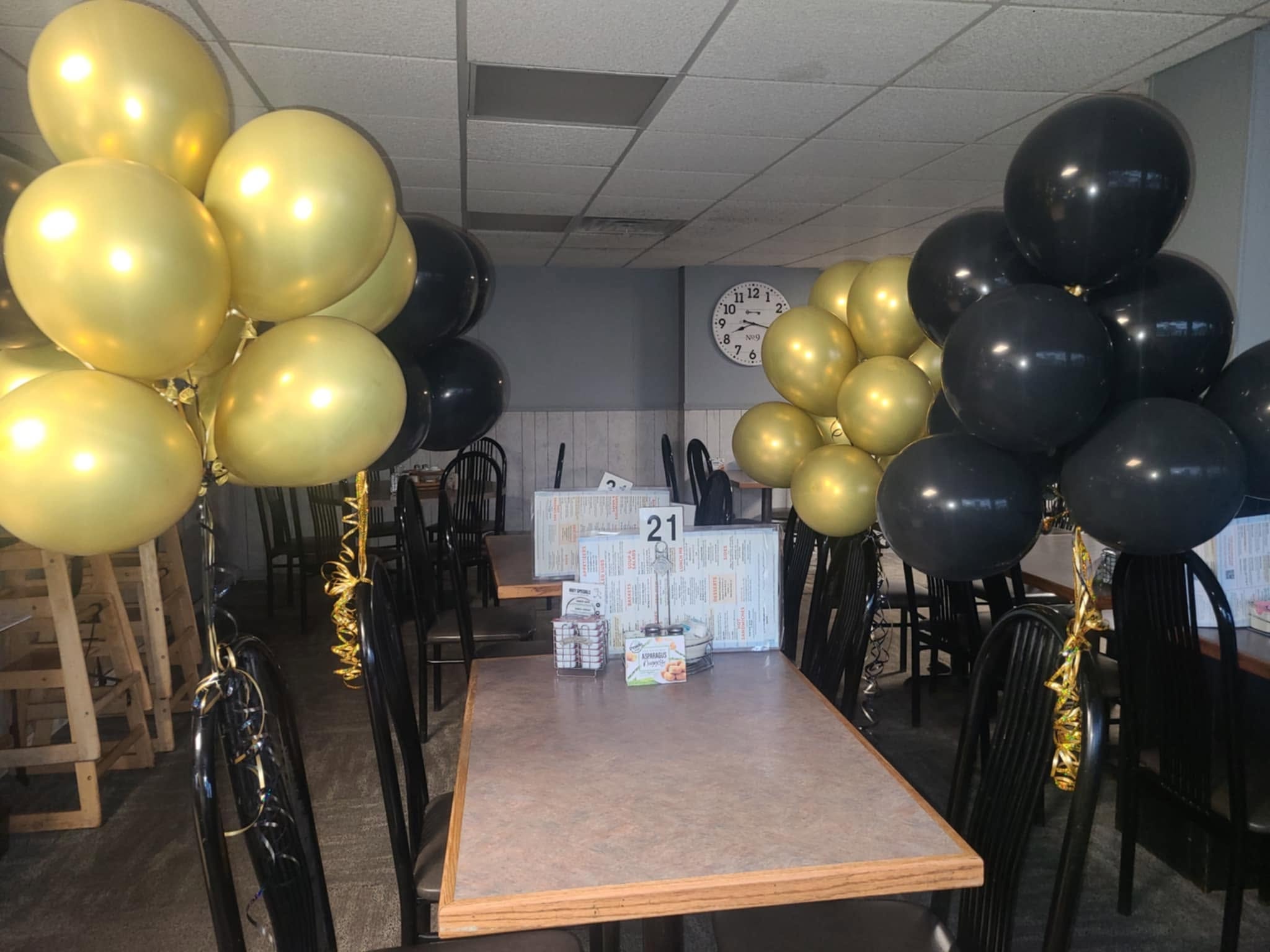 Gold and black helium balloon clusters in restaurant setting