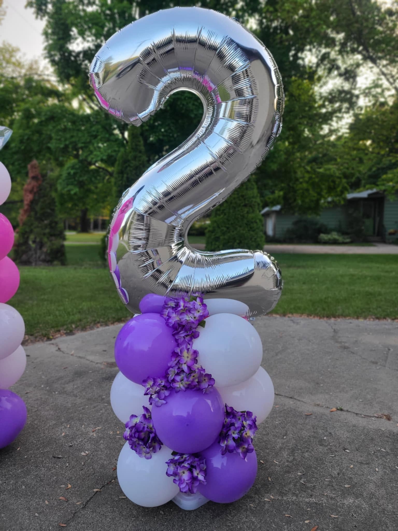 Silver number 2 balloon on purple and white column with floral accents