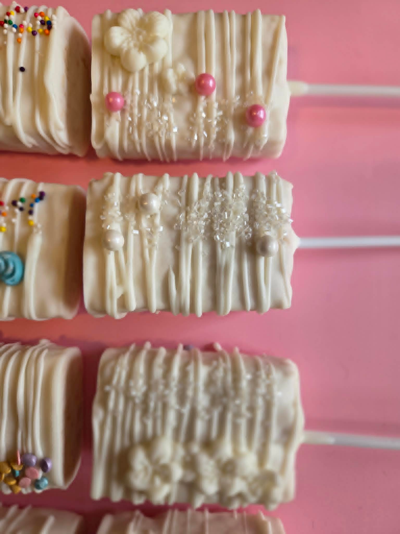 White chocolate Oreo pops with pink pearl and crystal sugar decorations
